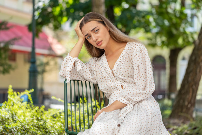 Worried woman sitting outdoors reflecting wedding family issues Worried woman sitting outdoors reflecting wedding family issues