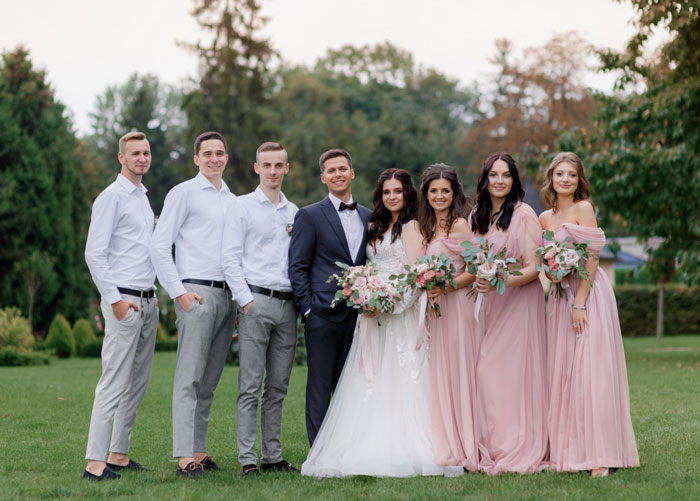 Bride with groom and bridesmaids in pink dresses outdoors Bride with groom and bridesmaids in pink dresses outdoors