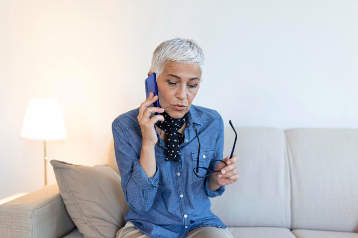 Woman on phone looking concerned amid family babysitting payment dispute Woman on phone looking concerned amid family babysitting payment dispute