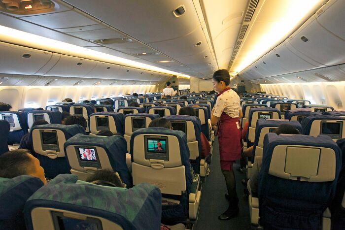 Airline cabin crew attending passengers in airplane interior