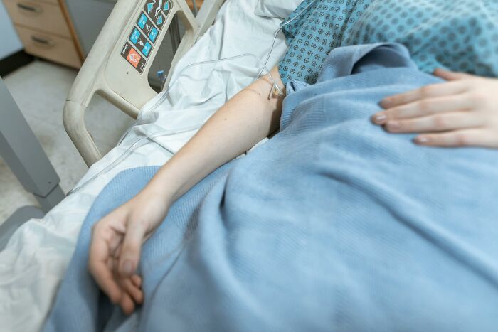 Hospital patient lying in bed with IV drip in medical setting
