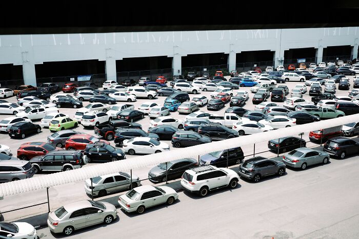 Crowded parking lot full of many cars outside a building