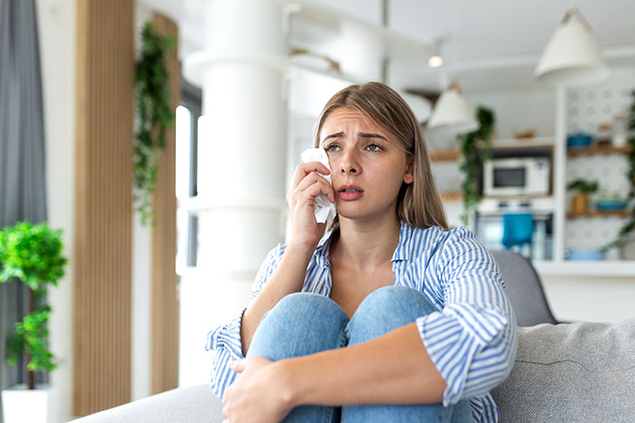 A woman is devastated, crying with a tissue, realizing her friendship with a bride has run its course.