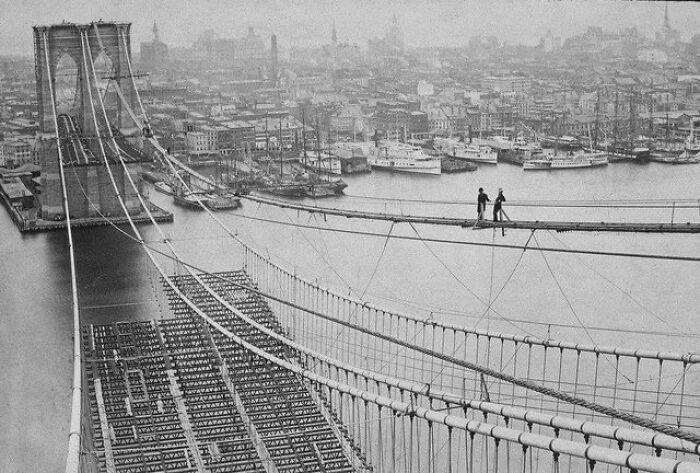 Historical photos: Two men walking on the suspension cables of the Brooklyn Bridge during its construction, an impossible to explain feat.