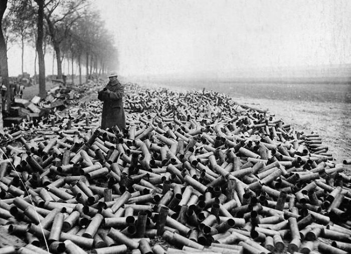 Historical photos: A soldier standing amidst a huge pile of spent artillery shells, an impossible to explain scene.