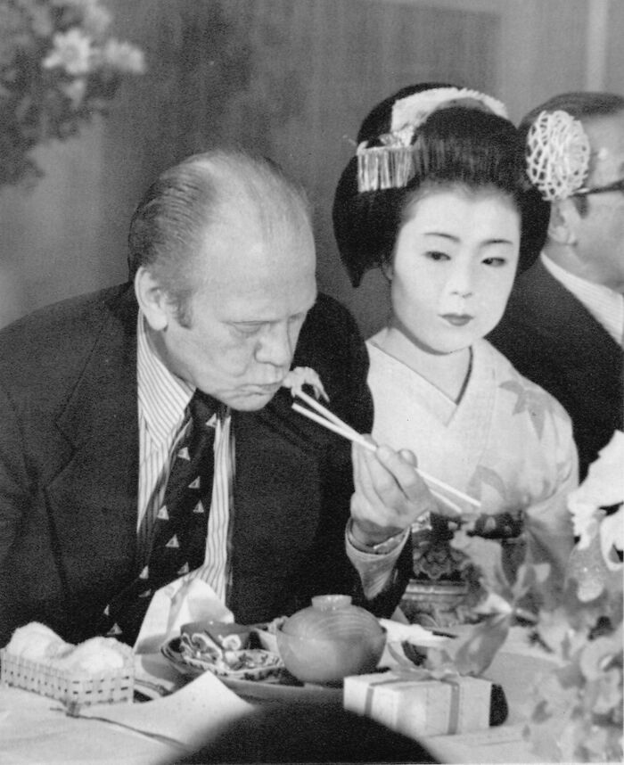 Historical photos of President Ford at a formal dinner, being offered food by a woman in traditional Japanese attire.