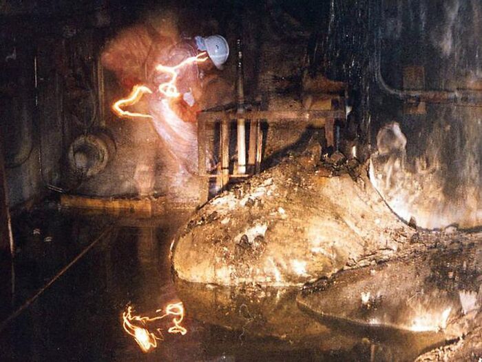 Historical photos of an impossible to explain image showing a person with a bright light trail in a dark, grimy industrial space.