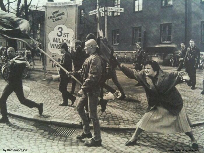 A woman attacking a protestor in a street, captured in a historical photo that feels almost impossible to explain.