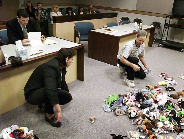 People in a courtroom with a pile of Beanie Babies, in a historical photo that feels almost impossible to explain.