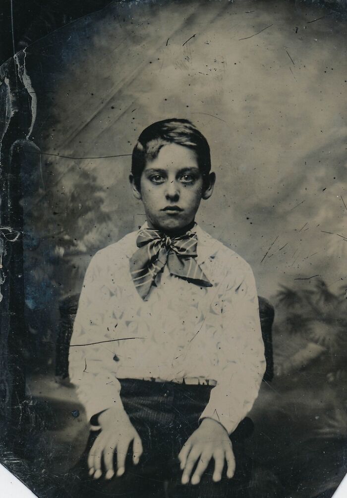 A historical photo of a boy in a bow tie with an intense gaze, an unexplainable and intriguing portrait from the past.
