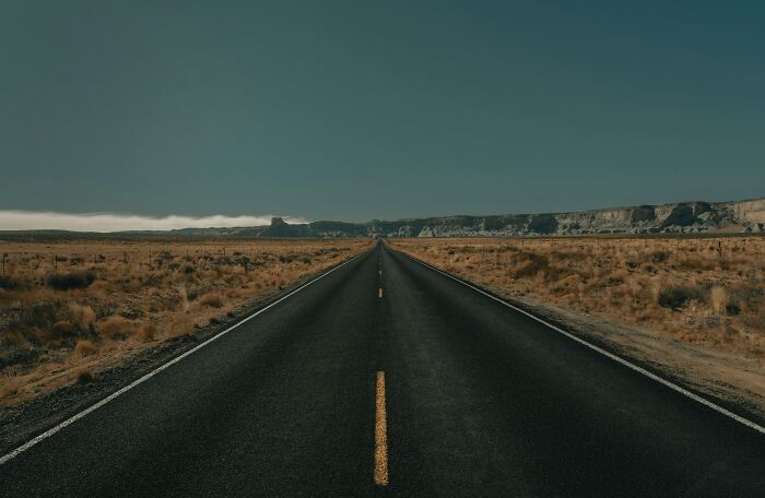 Empty open road in desert landscape representing freedom to travel