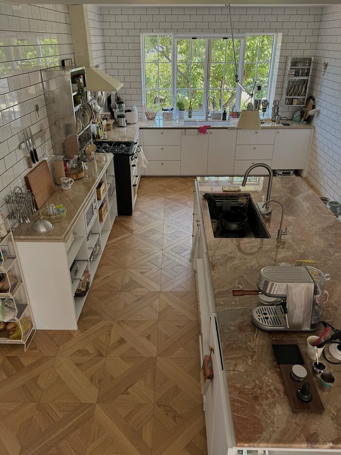 Modern kitchen with white cabinets and patterned wooden flooring interior design