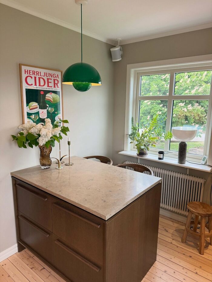 Compact kitchen island interior design with green pendant light and decor