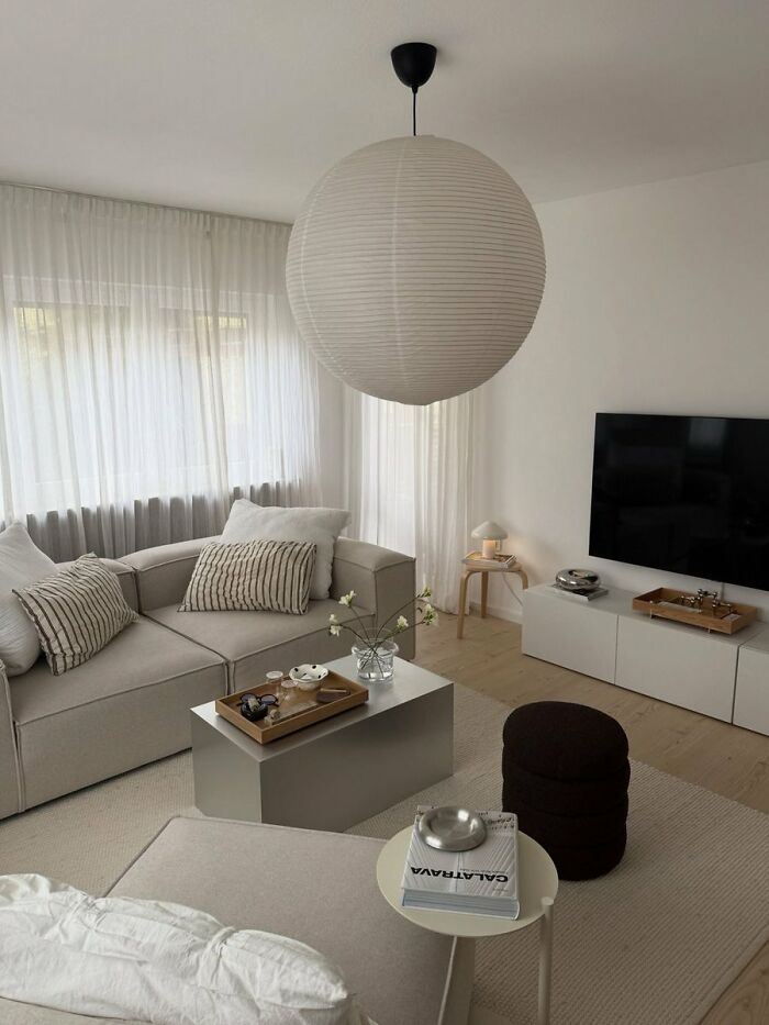 Minimalist living room with beige furniture and large round pendant light interior design