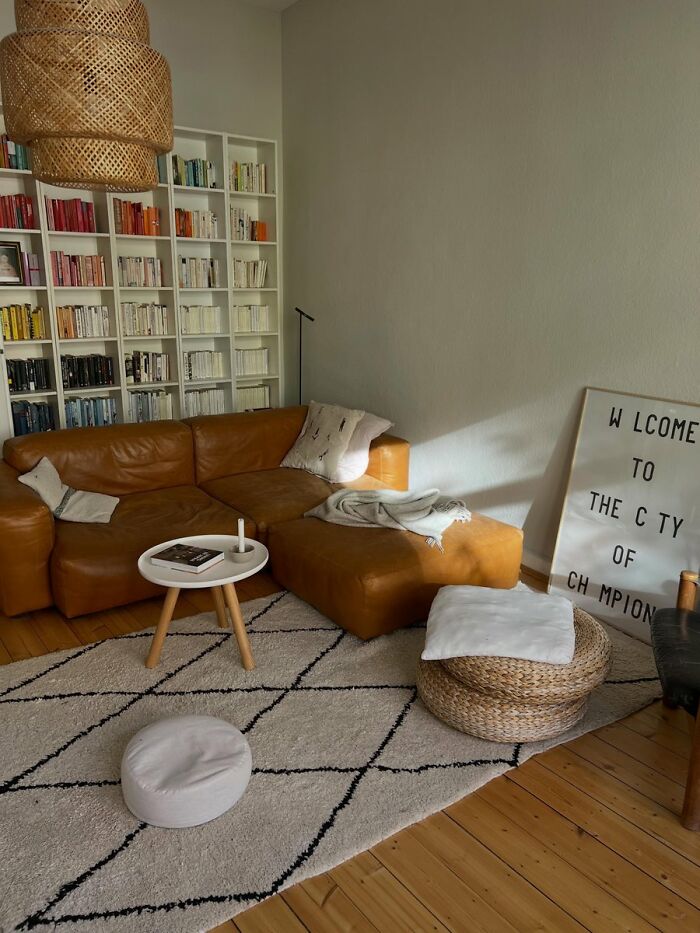 Minimalist living room with tan leather sofa and white patterned rug interior design ideas