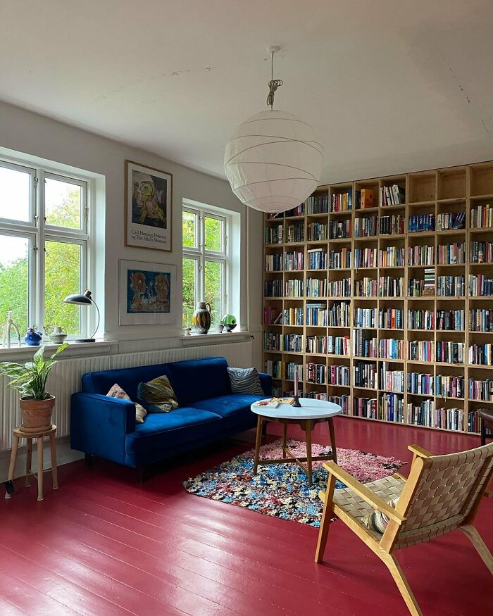 Cozy living room with blue sofa and wall-to-wall bookshelf in interior design