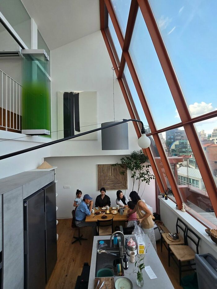 Modern dining room with large slanted windows and contemporary interior design