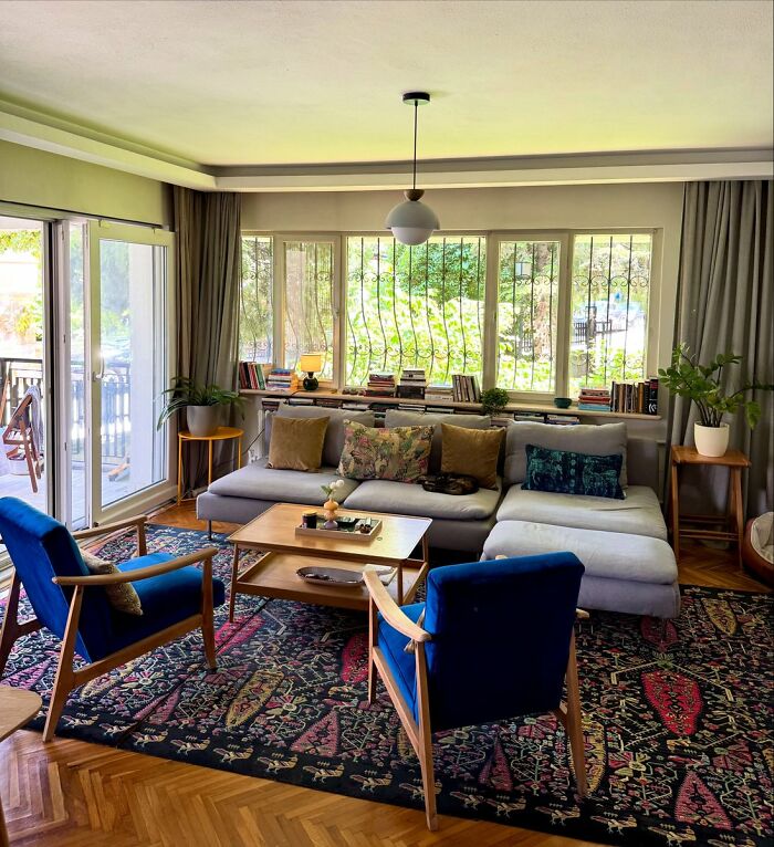 Bright living room interior design with blue chairs and patterned rug