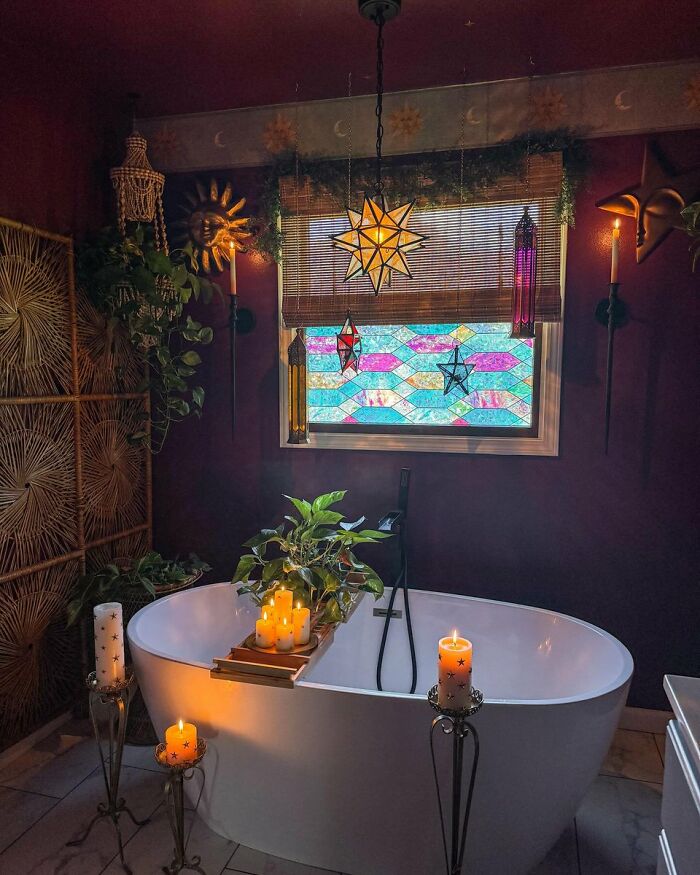 Moody bathroom with candles and stained glass window in cool interior design