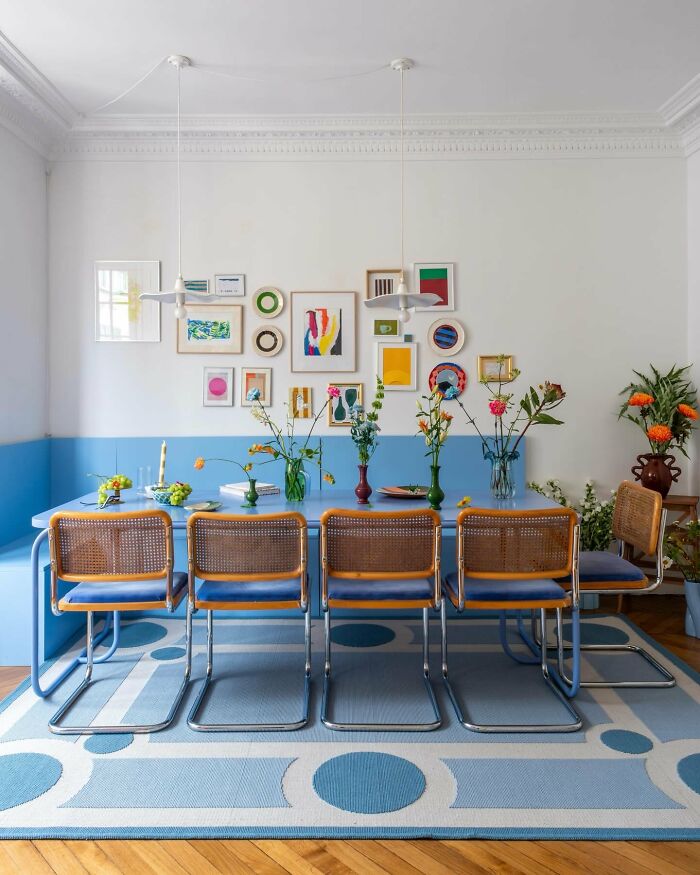 Colorful interior design dining room with blue table and floral wall art