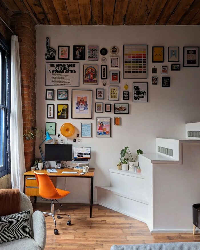 Interior design gallery wall above desk with orange chair and wooden floors