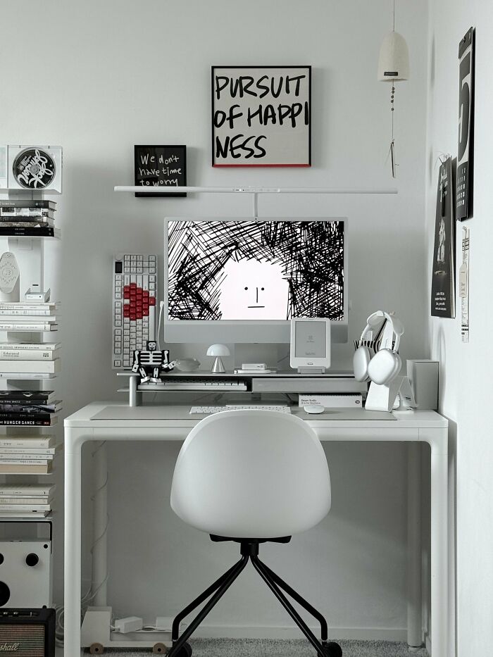 Minimalist interior design workspace with white desk and black and white artwork
