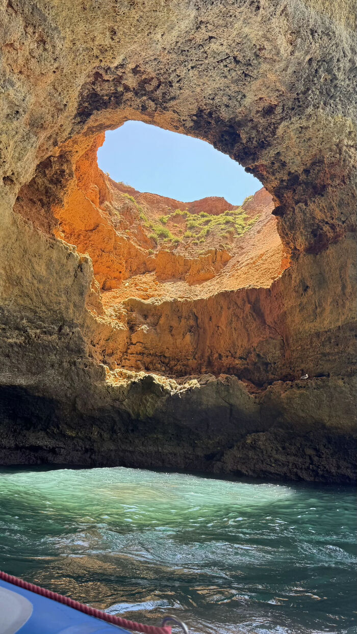 Natural cave opening with blue water and sunlight above