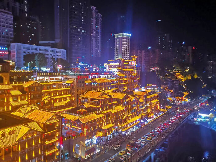 Aesthetic night view of illuminated traditional buildings in a cityscape with busy traffic