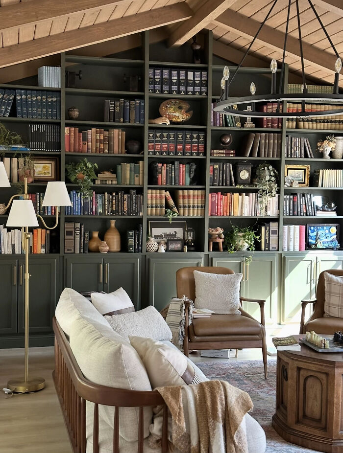 Aesthetic cozy living room with built-in bookshelves and vintage furniture under wooden ceiling