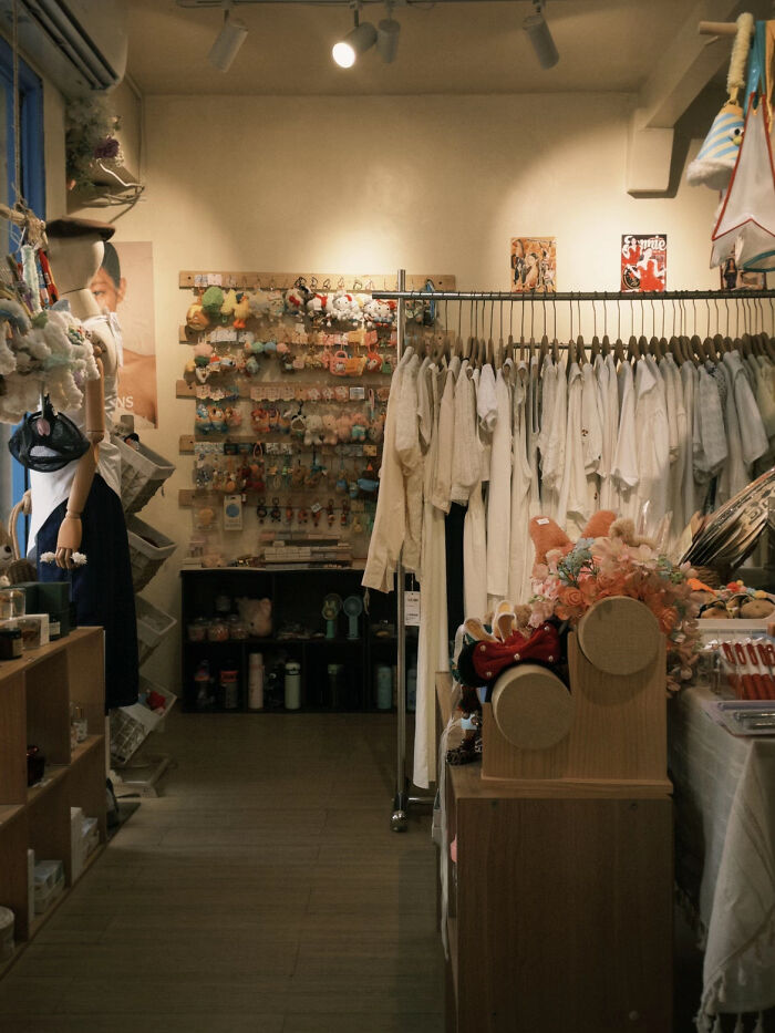 Aesthetic cozy boutique displaying white clothing and accessories indoors