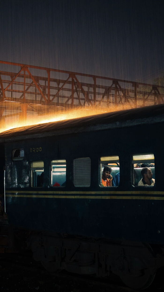 Aesthetic rainy night scene with lit train and glowing bridge overhead