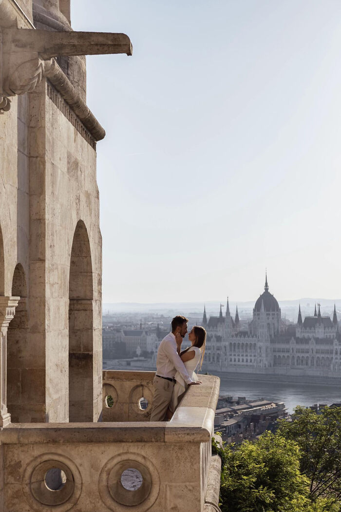 Aesthetic romantic couple embracing on a scenic balcony with historic architecture