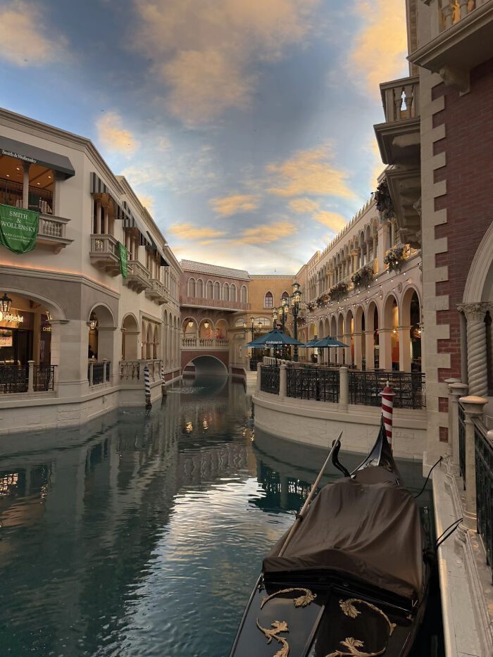 Aesthetic photo of Venetian-style canal with gondola under a painted sky ceiling
