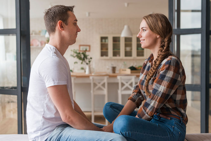 A couple looking at each other, depicting the husband whose wife's creepy friend flirts with him.
