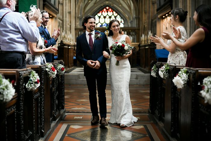 A bride and groom walking down a church aisle after their wedding, escaping an awkward situation.
