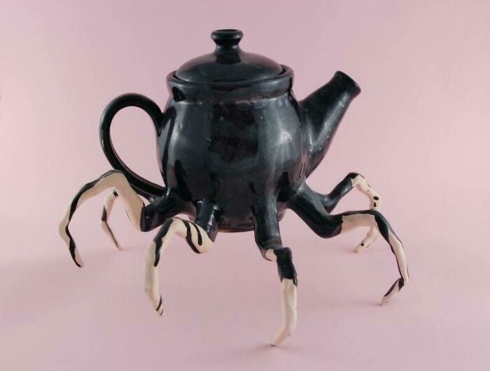 A bizarre black teapot with spider-like legs, raising questions with its unusual design.