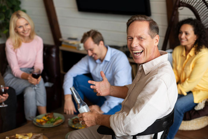 A happy dad laughs with friends and family, highlighting the double standard and his attitude towards women's periods. A happy dad laughs with friends and family, highlighting the double standard and his attitude towards women's periods.