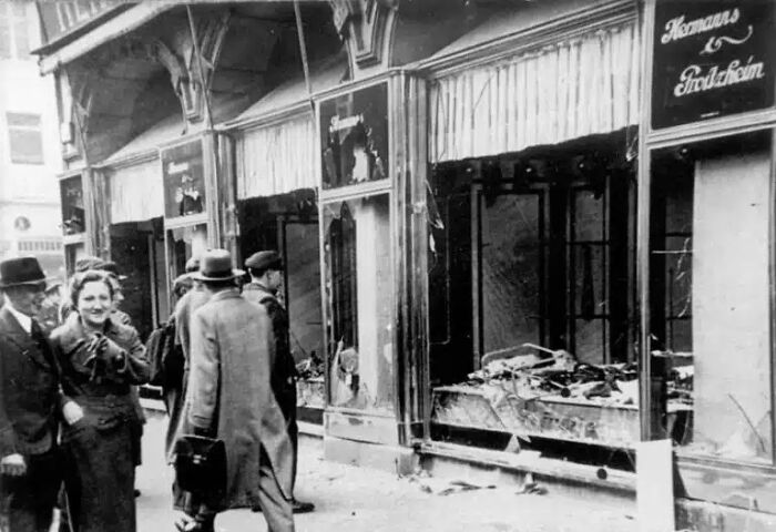 Historical photos: People walking past a storefront with shattered windows and debris on the ground.