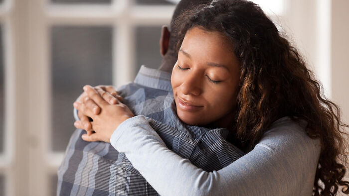 A woman embracing someone, representing comforting human behavior and emotional connection.