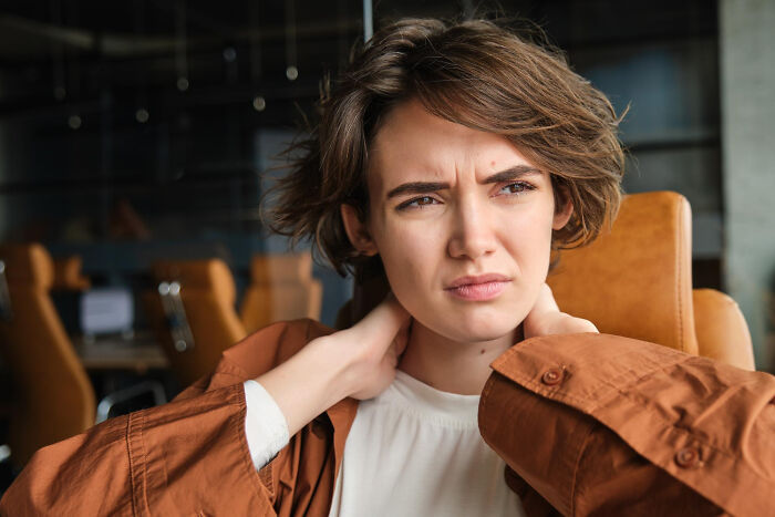 A woman expressing discomfort, illustrating a truth about human behavior and raw emotion.
