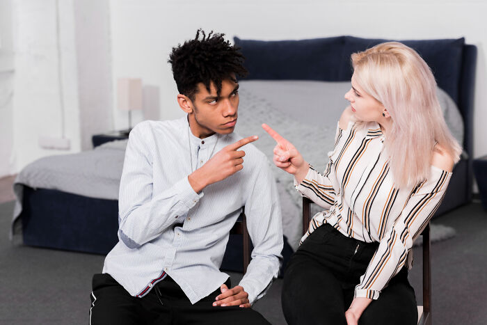 A couple engaged in an argument, pointing fingers at each other, illustrating truths about human behavior.