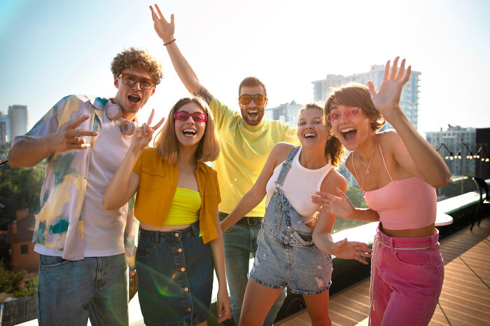A group of diverse friends celebrating on a rooftop, showing honest truths about human behavior.