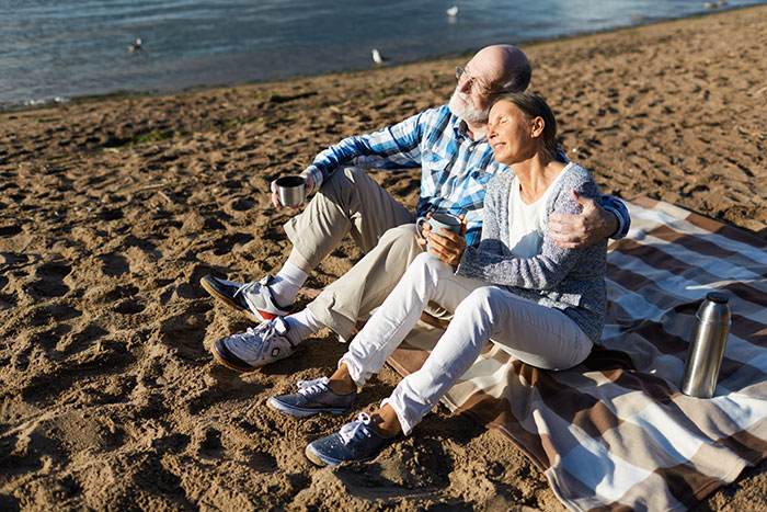 Parents sponsoring sister's trip: an elderly couple enjoying a sunny beach, exemplifying familial support and potentially unequal treatment. Parents sponsoring sister's trip: an elderly couple enjoying a sunny beach, exemplifying familial support and potentially unequal treatment.