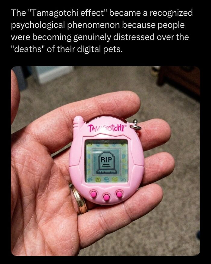 Hand holding a pink Tamagotchi device showing RIP digital pet