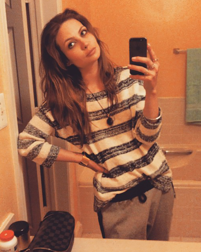 The Lilo & Stitch actress taking a selfie in a bathroom, wearing a striped shirt.