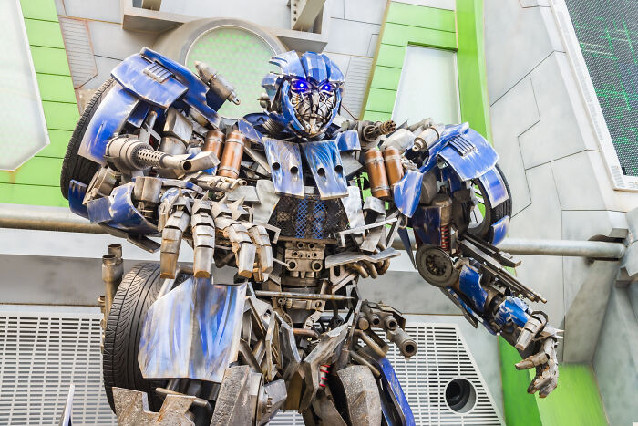 Blue robot with glowing eyes made of metal parts