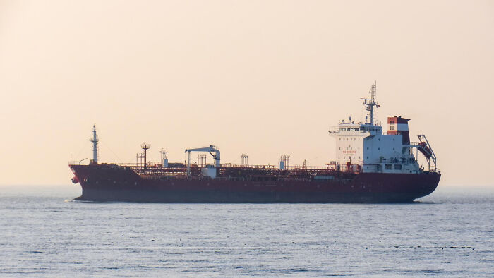 Large cargo ship sailing on calm ocean waters at sunset