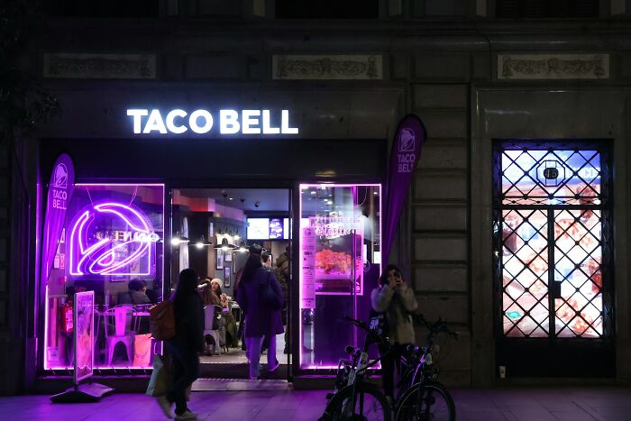 Taco Bell restaurant entrance illuminated with neon lights at night