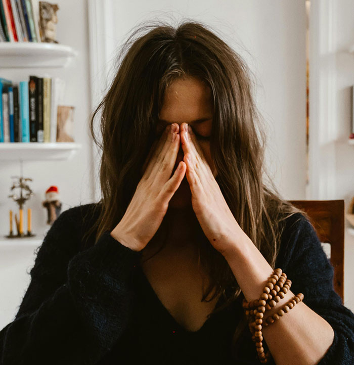 Woman stressed with hands on face showing signs of missed red flags after wedding