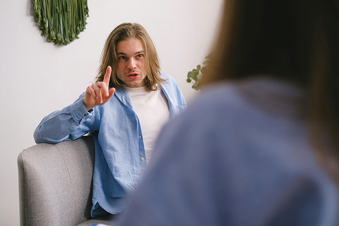 Young man warning with finger raised showing red flags women missed after the wedding
